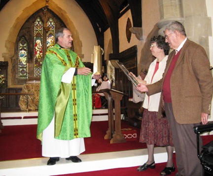 David presents Janet and Peter with a photo-montage of St Ninian's and 'a bottle'!